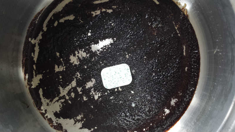 En maskinopvask tablet i den sorte gryde